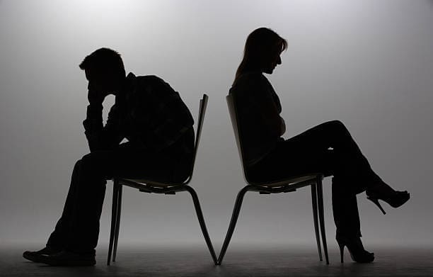 Man and woman sitting on chairs in silhouette
